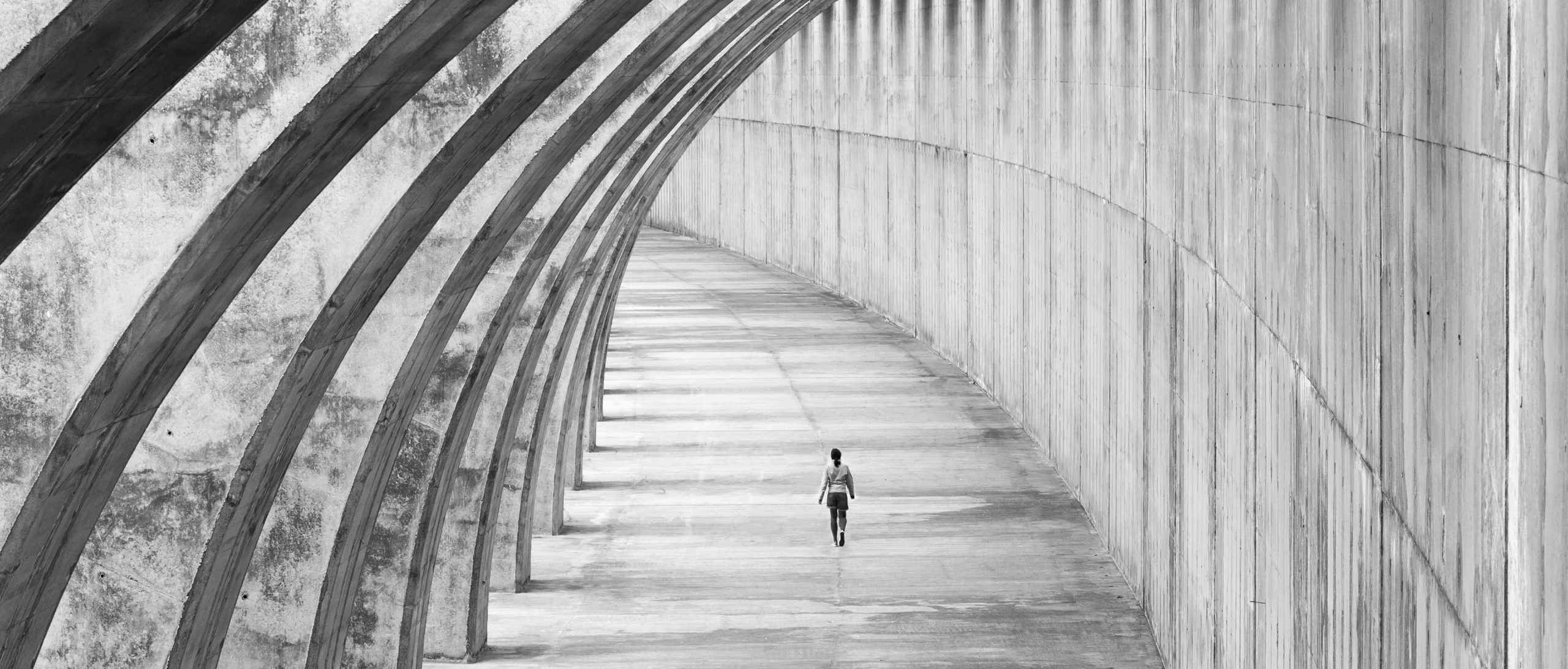 A person walks along an enclosed bridge.