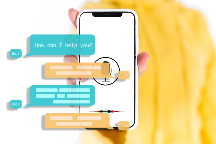 Chatbot Feedback Loops. A photograph of a hand holding a smartphone displaying a microphone symbol. Overlaid on the image is a conversation of a bot with an unknown person. The bot begins the conversation by asking How can I help you?