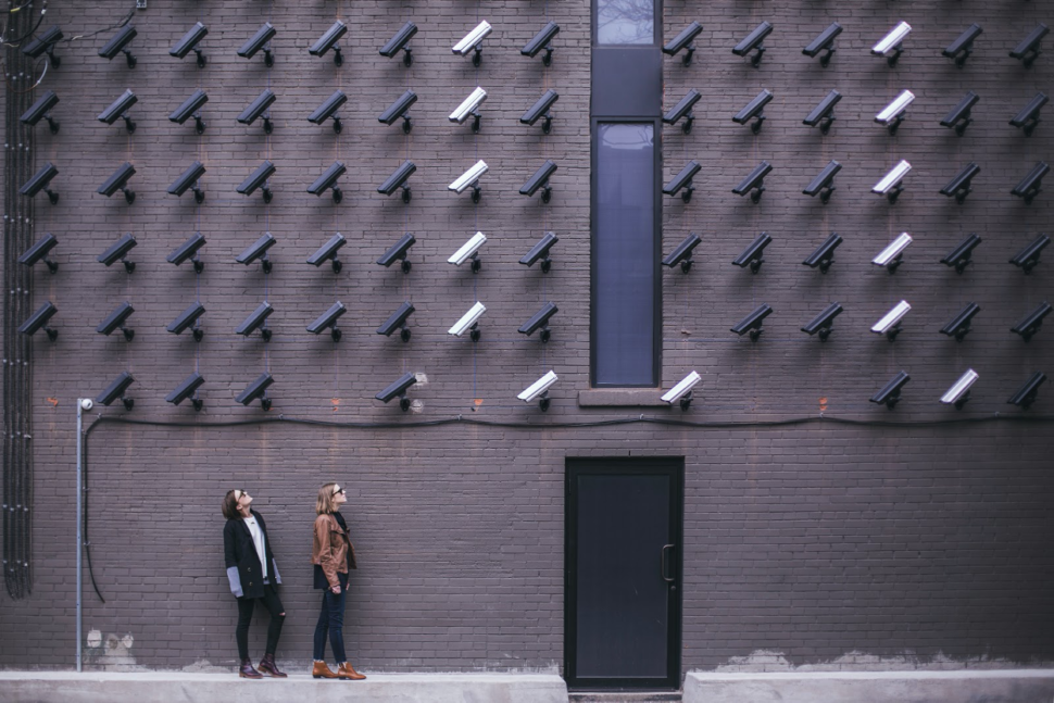 An array of security cameras face people on the street.