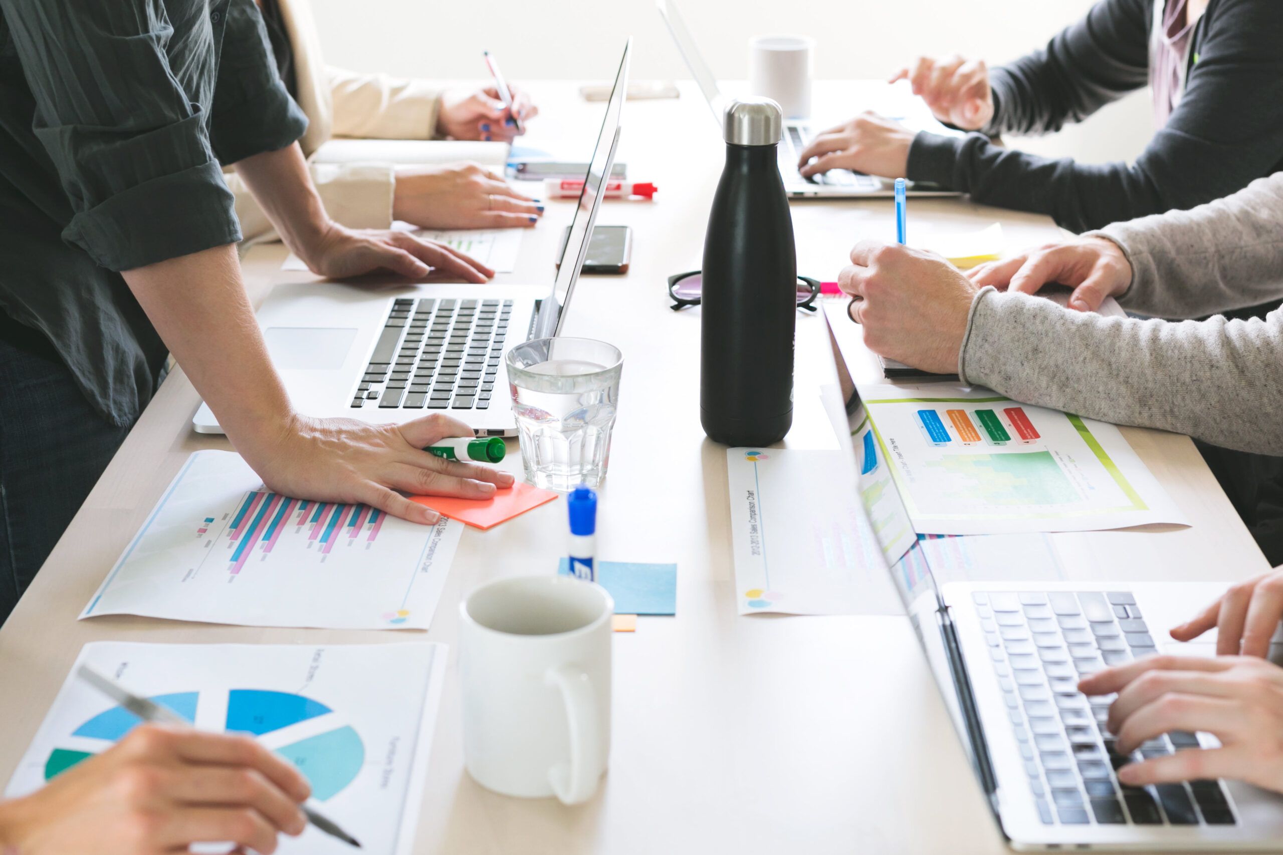 People meeting over reports and charts.